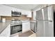 Kitchen features white cabinets, stainless steel appliances, brick backsplash, and light countertops at 27250 N 64Th St # 16, Scottsdale, AZ 85266