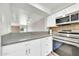 Modern kitchen with stainless steel appliances, white cabinets, and a view of the living area at 27250 N 64Th St # 16, Scottsdale, AZ 85266