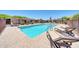 Community pool with lounge chairs, desert landscaping, and patio area at 27250 N 64Th St # 16, Scottsdale, AZ 85266