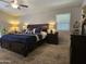 This bedroom features a ceiling fan, plush carpeting, and dark wood furniture at 2919 E Friess E Dr, Phoenix, AZ 85032