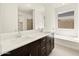 Bright bathroom featuring a double sink vanity with modern fixtures and a separate tub at 4035 S 176Th Dr, Goodyear, AZ 85338