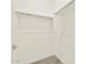 A simple walk-in closet features white walls, shelving, and carpeting at 4035 S 176Th Dr, Goodyear, AZ 85338