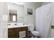 Cozy bathroom featuring a vanity with sink, toilet, and shower with a white curtain at 42006 W Hillman Dr, Maricopa, AZ 85138