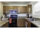 A closer view of the kitchen, highlighting the oven, microwave, sink, and countertop space at 42006 W Hillman Dr, Maricopa, AZ 85138