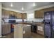 Traditional kitchen featuring stainless steel appliances, wooden cabinetry, and a functional center island at 42006 W Hillman Dr, Maricopa, AZ 85138