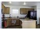 Functional kitchen with wood cabinets, an island, and black appliances at 42006 W Hillman Dr, Maricopa, AZ 85138