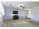 Bright and airy living room with neutral carpet, a ceiling fan, and a TV at 42006 W Hillman Dr, Maricopa, AZ 85138