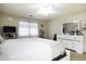 Spacious main bedroom with a dresser, TV, and large windows dressed with sheer curtains at 42006 W Hillman Dr, Maricopa, AZ 85138
