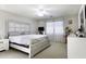 Bright main bedroom with a large bed, white furniture, and soft natural lighting at 42006 W Hillman Dr, Maricopa, AZ 85138