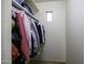 Organized walk-in closet featuring ample hanging space, top shelves, and neutral-colored carpet at 42006 W Hillman Dr, Maricopa, AZ 85138