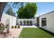 The backyard is beautifully landscaped with artificial grass, planters, pavers, and privacy wall at 4336 E Piccadilly Rd, Phoenix, AZ 85018