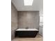 Spa-like bathroom featuring a modern bathtub, recessed lighting, and gray tiled walls at 4336 E Piccadilly Rd, Phoenix, AZ 85018