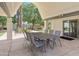 Covered outdoor patio with metal table, chairs, and well manicured grounds at 4336 E Piccadilly Rd, Phoenix, AZ 85018