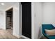This sitting room features a blue chair with a custom closet featuring wood shelving behind a shade at 4336 E Piccadilly Rd, Phoenix, AZ 85018