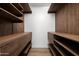 Walk-in closet with custom wood shelving, drawers, and wood-look floors offer space and organization at 4336 E Piccadilly Rd, Phoenix, AZ 85018