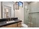 Well-lit bathroom features glass shower, modern fixtures, and a sleek vanity with a dark countertop at 4456 E Earll Dr, Phoenix, AZ 85018