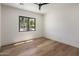 Inviting bedroom featuring a black ceiling fan, hardwood floors, and natural light through large window at 4456 E Earll Dr, Phoenix, AZ 85018