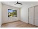 Bright bedroom featuring wood floors, a black-framed window, and a closet with sliding doors at 4456 E Earll Dr, Phoenix, AZ 85018