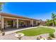 Backyard with covered patio, artificial grass, desert landscaping and a birdbath at 4626 E Blue Spruce Ln, Gilbert, AZ 85298