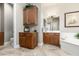 Bathroom with beautiful tile flooring, wood cabinets, vanity, and framed art above the bathtub at 4626 E Blue Spruce Ln, Gilbert, AZ 85298