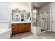 Bathroom featuring a walk-in shower with glass door and wood vanity with double sinks at 4626 E Blue Spruce Ln, Gilbert, AZ 85298