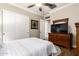 Bedroom offering a closet, wood dresser with television, ceiling fan, and open doorway at 4626 E Blue Spruce Ln, Gilbert, AZ 85298