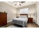 Comfortable bedroom with a ceiling fan, wood dresser, nightstands, and coordinated lamps at 4626 E Blue Spruce Ln, Gilbert, AZ 85298