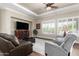 Comfortable living room with a fireplace, plantation shutters, and neutral decor at 4626 E Blue Spruce Ln, Gilbert, AZ 85298