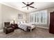 Cozy main bedroom with a ceiling fan, plush carpet, and bright windows at 4626 E Blue Spruce Ln, Gilbert, AZ 85298