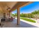 Patio with covered seating area and artificial grass bordered with green bushes in backyard at 4626 E Blue Spruce Ln, Gilbert, AZ 85298