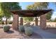 Charming pavilion with stone columns, seating, and mature landscaping at 4626 E Blue Spruce Ln, Gilbert, AZ 85298