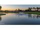 Scenic pond view with a fountain and surrounding green space with palm trees at sunset at 4626 E Blue Spruce Ln, Gilbert, AZ 85298