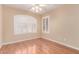 A sunlit bedroom with hardwood floors, ceiling fan, and white shuttered windows for adjustable light at 4826 W Ardmore Rd, Laveen, AZ 85339