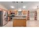 Well-lit kitchen with wood cabinets, stainless appliances, a functional island, and tile flooring at 4826 W Ardmore Rd, Laveen, AZ 85339