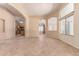 Bright living room with neutral paint, tile flooring, and archways leading to the kitchen at 4826 W Ardmore Rd, Laveen, AZ 85339