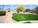 Expansive backyard featuring lush artificial turf, stone pathway, mature landscaping, and block wall at 5014 E Kirkland Rd, Phoenix, AZ 85054