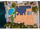 Aerial view of a home with a unique pool shape, dock, a yard, and solar panels on a sunny day at 5510 W Arrowhead Lakes Dr, Glendale, AZ 85308