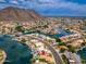 Wide aerial shot of a neighborhood showcasing waterfront properties, boat docks, and stunning mountain views at 5510 W Arrowhead Lakes Dr, Glendale, AZ 85308