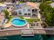 Beautiful backyard featuring a unique kidney shaped pool, dock, patio seating, and lush waterfront on a sunny day at 5510 W Arrowhead Lakes Dr, Glendale, AZ 85308