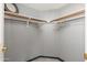A well lit closet with grey walls, wooden shelves and grey laminate flooring at 5510 W Arrowhead Lakes Dr, Glendale, AZ 85308