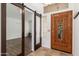 Elegant entryway with tile flooring, sliding barn doors, and a decorative wooden door with ornate hardware at 5510 W Arrowhead Lakes Dr, Glendale, AZ 85308