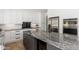 Modern kitchen featuring an island with granite countertops, white cabinets, and stainless steel appliances at 5510 W Arrowhead Lakes Dr, Glendale, AZ 85308