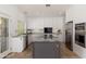 Modern kitchen featuring an island with granite countertops, white cabinets, and stainless steel appliances at 5510 W Arrowhead Lakes Dr, Glendale, AZ 85308