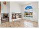 Bright living room with fireplace and large window overlooking a pool and lake at 5510 W Arrowhead Lakes Dr, Glendale, AZ 85308