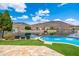Beautiful backyard with a sparkling pool, lush turf, and a serene lake backdrop at 5510 W Arrowhead Lakes Dr, Glendale, AZ 85308
