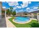 Relaxing pool area with stone decking, artificial grass, and a scenic lake view at 5510 W Arrowhead Lakes Dr, Glendale, AZ 85308