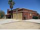 Stucco house with a red-tiled roof, palm trees, and boarded up windows in need of repair at 5716 E Desert Vista Trl, Cave Creek, AZ 85331