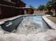 View of the home's exterior featuring a pool with a safety net, concrete edging, and grassy yard at 5716 E Desert Vista Trl, Cave Creek, AZ 85331