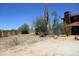 Exterior view of the yard that includes various vegetation and a stucco house with a red tiled roof at 5716 E Desert Vista Trl, Cave Creek, AZ 85331