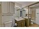 Bright bathroom featuring a wooden vanity, white countertop, framed mirror, and updated lighting at 602 N May -- # 17, Mesa, AZ 85201